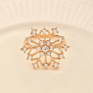 Vue détaillée d'un rond de serviette flocon doré serti de strass sur une assiette