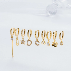 Polished gold earrings set with micro-inlaid zircon pendants in star and drop shapes