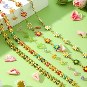 Collier chaîne en acier doré avec breloques marguerites et feuilles en émail coloré