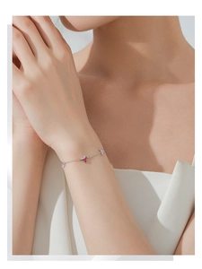 Détail d'un bracelet en argent avec des pierres rose et magenta en forme de pétales