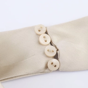 Vue détaillée de la manche en satin champagne avec quatre élégants boutons ronds