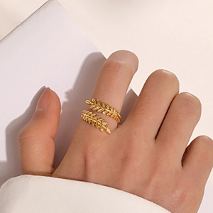 Bague feuille dorée ajustable en acier inoxydable portée au doigt dans un style minimaliste