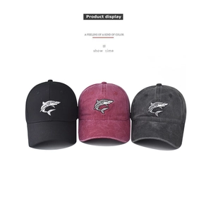 Detailed display of three washed cotton baseball caps with embroidered shark logos