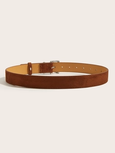 Detail of a brown suede belt featuring a silver pin buckle and textured leather finish