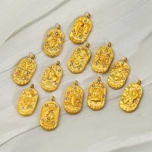 Golden zodiac tarot card pendants with white zircon inlay on white textured fabric