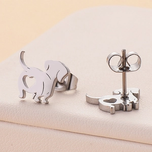 Macro shot of silver stainless steel dachshund stud earrings with cutout heart detail