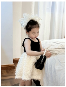 Detail of girl's black and white knit tutu dress with feather mesh and flower headband
