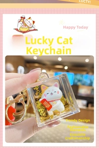Close-up of Maneki Neko keychain featuring golden glitter sand and clear acrylic shell