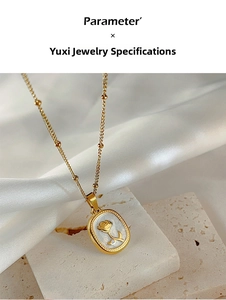 Macro detail of enamel rose pendant necklace with gold chain on silk fabric