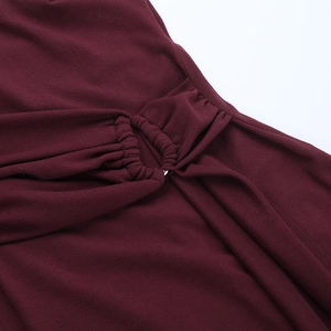 Detail of wine red dress with elegant ruching and metallic ring hardware