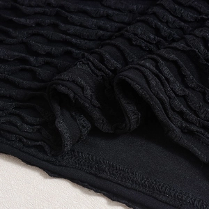 Makroaufnahme von schwarzem Faltenstoff und feiner Saumnaht am sexy Kleid mit Ausschnitt