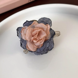 Close-up of a gradient camellia flower hair clip with blue petals and a pink core