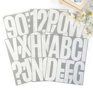 Close-up of 5-inch white matte heat transfer letter and number stickers on white desk