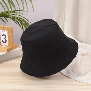 Detailed close-up of a black cotton bucket hat texture on a wooden desk background