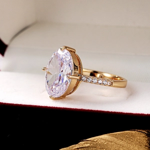 Macro shot of large oval-cut cubic zirconia gold ring in luxury jewelry gift box
