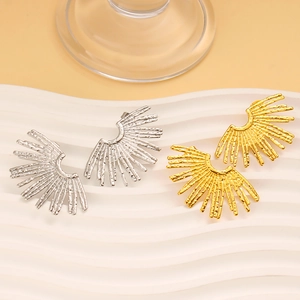Detailed view of gold and silver fan-shaped earrings with textured bohemian finish