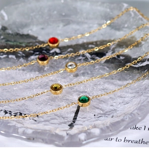 Detail of five-color round crystals on 18K gold-plated chains over textured glass