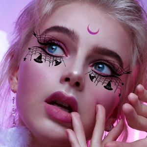 Halloween face tattoo stickers with spider web and moon patterns on a female model