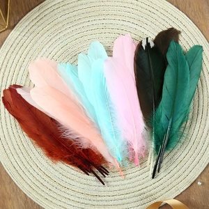 Close-up of colorful DIY goose feathers for dreamcatchers on a woven mat
