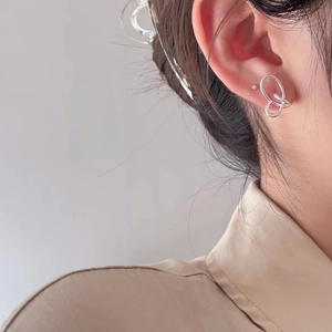 Detail of 925 sterling silver woven stud earrings on ear for a minimalist look