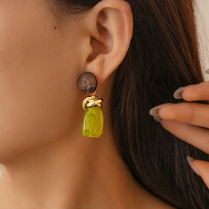 Macro shot of geometric resin drop earrings in vintage tortoiseshell and green tones