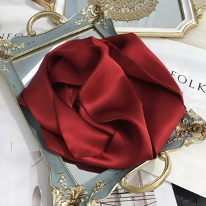 Close-up of elegant red silk scarf on a vintage gold mirror tray with luxurious texture