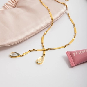 Detail of 18K gold stainless steel snake chain necklace with green teardrop pendants