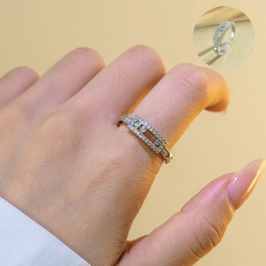 Macro detail showing a silver rectangular frame ring with three sliding stones and pave crystals