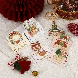 Assorted gold foil Christmas mini cards with festive patterns on white plush background