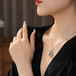 Close-up of emerald green zircon gourd pendant necklace worn on a fashion model's neck