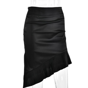 Detail of black satin skirt featuring an irregular hemline and pleated bottom trim
