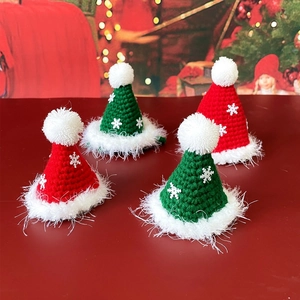 Detail of red and green knitted Christmas hats with plush white pom-poms for pets