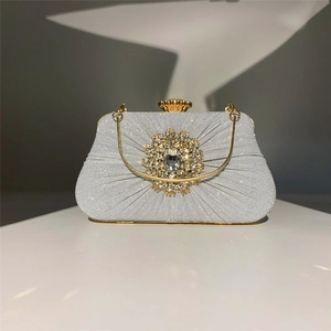 Detailed macro view of silver pleated evening clutch bag with crystal gemstone clasp and chain