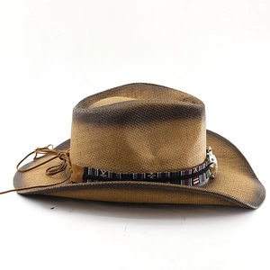 Detail of a western straw sun hat with ethnic braid and silver skull metal buckle