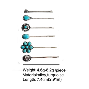 Detail view showing a set of six vintage turquoise hair clips with alloy floral designs