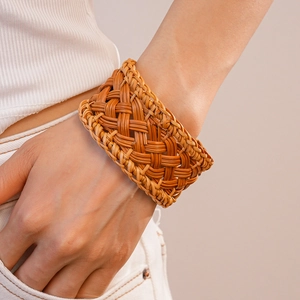 Detailed macro view of handmade woven rattan wide cuff bracelet with geometric texture