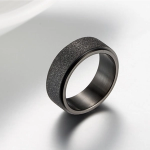 Frosted black titanium steel spinner ring with a smooth inner band for anxiety relief
