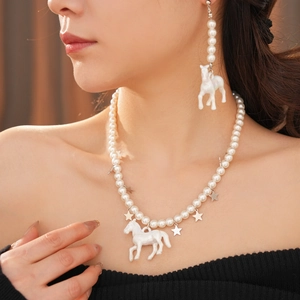 Detail view of pearl necklace with white horse pendant and silver star charms on model