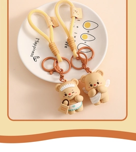 Macro view of butter bear cartoon keychains with woven straps and painted metal rings