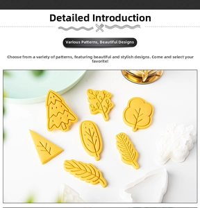 Close-up of yellow and white plastic Christmas tree and leaf cookie cutters for DIY baking