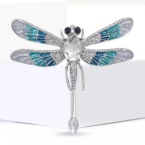 Detail of silver dragonfly brooch with blue enamel wings and sparkling crystals