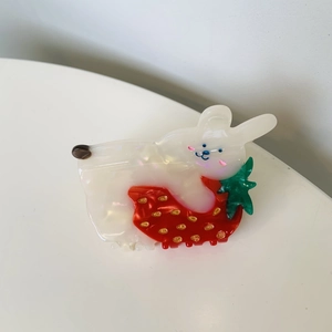 Detailed view of acetate hair claw clip featuring a cute rabbit with red strawberry design