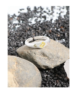 Macro shot of S925 silver ring featuring a yellow zircon on grey stone background