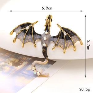 Detail view of a golden dragon brooch with enamel and rhinestones showing 6.9x5.7cm size