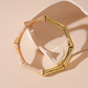 Gros plan détaillé du bracelet en acrylique style bambou avec joints en métal doré