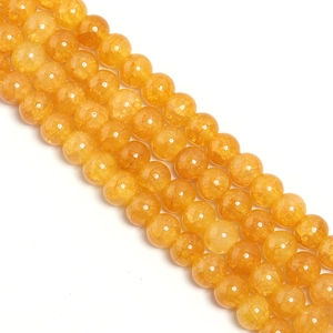 Close-up of translucent yellow glass beads with internal ice crack texture for DIY jewelry