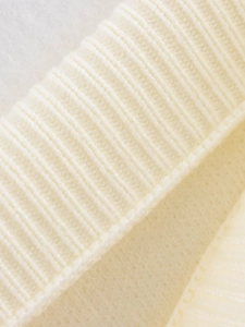 Detailansicht des cremefarbenen Strickpullovers mit hochwertiger Rippstruktur und Wolle