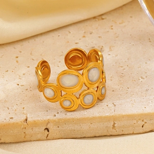 Gold-plated geometric open ring with white enamel inlay on a natural stone surface