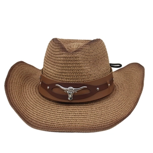 Detail of brown straw cowboy hat featuring leather band and silver longhorn emblem