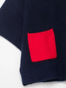 Detail view of navy blue knit shirt featuring a bright red fuzzy textured pocket